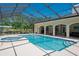 Inviting screened-in pool with a spa, perfect for relaxation and outdoor entertaining at 3452 Forelock Rd, Tarpon Springs, FL 34688