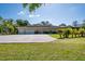 Exterior view of a home showcasing the back of the house, three-car garage, and spacious backyard at 3452 Forelock Rd, Tarpon Springs, FL 34688
