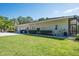 Side and back exterior of home with well-maintained lawn, leading to a screened-in porch at 3452 Forelock Rd, Tarpon Springs, FL 34688