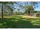 A sprawling green lawn with scattered mature trees and a traditional wooden fence at 3452 Forelock Rd, Tarpon Springs, FL 34688
