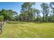Expansive grassy yard with a classic wooden fence and mature shade trees at 3452 Forelock Rd, Tarpon Springs, FL 34688