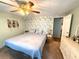 A bedroom featuring floral wallpaper and a comfortable bed, creating a serene and inviting atmosphere at 3910 Sarah Dr, Wesley Chapel, FL 33543