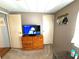 Bedroom features a dresser with a TV and neutral colored walls at 3910 Sarah Dr, Wesley Chapel, FL 33543