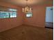 Carpeted dining room featuring a charming chandelier and ample natural light at 503 Sunset Rd, Plant City, FL 33563