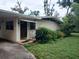 Charming home exterior with a covered entryway and lush, mature landscaping at 503 Sunset Rd, Plant City, FL 33563