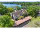 Aerial view showcasing a three-story townhome with covered parking and a scenic lake backdrop at 5122 Puritan Cir # 5122, Tampa, FL 33617