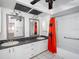 Bathroom with double sinks, white cabinetry, and shower-tub combination with a bright orange shower curtain at 5122 Puritan Cir # 5122, Tampa, FL 33617