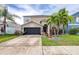 Charming two-story home with a well-maintained lawn and landscaping featuring palm trees and flowering plants at 533 Vista Ridge Dr, Ruskin, FL 33570