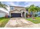 Charming two-story home with a well-maintained lawn and landscaping featuring palm trees and flowering plants at 533 Vista Ridge Dr, Ruskin, FL 33570