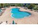Overhead shot of a clover-shaped pool with ample lounge seating and tables with umbrellas at 533 Vista Ridge Dr, Ruskin, FL 33570