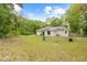 Expansive backyard featuring a well-maintained lawn, solar panels and mature trees on this country property at 5422 Wilkins Trl, Brooksville, FL 34602