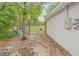 Serene backyard space featuring a gate leading to a large lot surrounded by lush green trees and natural landscape at 5422 Wilkins Trl, Brooksville, FL 34602