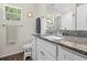 Bathroom featuring granite countertop, framed mirror, and a window providing natural light at 5422 Wilkins Trl, Brooksville, FL 34602