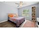 Inviting bedroom with a ceiling fan, natural light from the window, and a cozy rug on the wood-look floor at 5422 Wilkins Trl, Brooksville, FL 34602