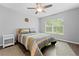 Well-lit bedroom features natural light, a ceiling fan, a large window and a comfortable bed with colorful bedding at 5422 Wilkins Trl, Brooksville, FL 34602