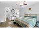 Bedroom featuring ceiling fan, wood-look floors, and doorways to the bathroom and closet at 5422 Wilkins Trl, Brooksville, FL 34602