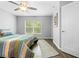 Bright bedroom features a ceiling fan, wood-look floors, and a window view of the lush, green outdoors at 5422 Wilkins Trl, Brooksville, FL 34602