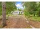 Charming single-story home with an attached garage and a well-manicured front yard surrounded by mature trees at 5422 Wilkins Trl, Brooksville, FL 34602