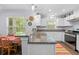Bright kitchen with granite counters, stainless appliances, white cabinets, a window view and an attached dining space at 5422 Wilkins Trl, Brooksville, FL 34602