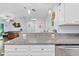 Open concept kitchen with granite counters, white cabinets, pendant lighting and connection to the living area at 5422 Wilkins Trl, Brooksville, FL 34602
