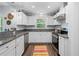 Bright kitchen with granite counters, stainless appliances, window view and white cabinetry and colorful floor rug at 5422 Wilkins Trl, Brooksville, FL 34602