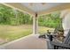 Back patio with seating area and view of the green backyard at 5422 Wilkins Trl, Brooksville, FL 34602