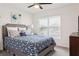 Bright bedroom features a patterned duvet cover, soft carpet, and lots of natural light from the window at 5687 Barakat Rd, Zephyrhills, FL 33541