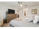 The primary bedroom boasts soft carpet, a ceiling fan, a dresser and access to the en suite bathroom at 5687 Barakat Rd, Zephyrhills, FL 33541