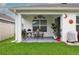 Covered patio features an outdoor dining set, potted plants and decor, creating a comfortable backyard space at 5687 Barakat Rd, Zephyrhills, FL 33541