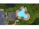 Aerial shot of a uniquely shaped community pool, featuring ample seating and landscaping at 5687 Barakat Rd, Zephyrhills, FL 33541