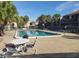 A community pool surrounded by tropical palm trees and condominium units with plenty of space for outdoor seating at 6306 Newtown Cir # 6A3, Tampa, FL 33615