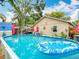 Lovely backyard featuring a refreshing pool with lounge float, patio set, and verdant landscaping at 6425 S Adelia Ave, Tampa, FL 33616
