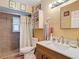 Bathroom featuring a shower with tile surround, toilet, mirror and sink at 6425 S Adelia Ave, Tampa, FL 33616
