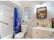 Bathroom featuring a shower with blue curtain, toilet, mirror and sink at 6425 S Adelia Ave, Tampa, FL 33616