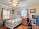 Bedroom features wood floors, ceiling fan and a window to allow ample natural light at 6425 S Adelia Ave, Tampa, FL 33616