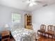Cozy bedroom features wood flooring, a ceiling fan, and ample natural light at 6425 S Adelia Ave, Tampa, FL 33616