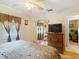 Bedroom with ceiling fan, wood floors, and a closet with mirrored doors at 6425 S Adelia Ave, Tampa, FL 33616