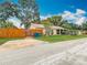 Charming home boasts a well-manicured lawn, mature trees, and a warm, inviting exterior during the day at 6425 S Adelia Ave, Tampa, FL 33616