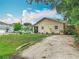 Charming home with a spacious front yard, gravel driveway, and well-maintained landscaping at 6425 S Adelia Ave, Tampa, FL 33616