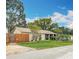 Charming home boasts a well-manicured lawn, mature trees, and a warm, inviting exterior during the day at 6425 S Adelia Ave, Tampa, FL 33616