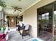 Relaxing covered porch features comfortable seating, a ceiling fan, and a view of the surrounding landscape at 6425 S Adelia Ave, Tampa, FL 33616