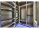 Walk-in closet with custom shelving, cabinetry, and contemporary design elements at 6528 Simone Shores Cir, Apollo Beach, FL 33572