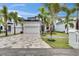 Modern two-story home featuring a paver driveway, attached garage, and tropical landscaping with palm trees at 6528 Simone Shores Cir, Apollo Beach, FL 33572