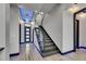 Grand foyer with glass-railed staircase, modern lighting, and elegant tile flooring at 6528 Simone Shores Cir, Apollo Beach, FL 33572