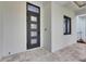 Modern home features a black front door and window with stone pavers and lush landscaping at 6528 Simone Shores Cir, Apollo Beach, FL 33572