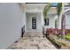 Modern home entryway with black door, stone steps and pavers, and professionally landscaped yard at 6528 Simone Shores Cir, Apollo Beach, FL 33572