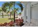 Landscaped front yard and covered porch area with stone pavers and tropical palm trees at 6528 Simone Shores Cir, Apollo Beach, FL 33572