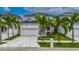 Beautiful two-story home with lush landscaping, a patterned driveway, and a white three-car garage at 6528 Simone Shores Cir, Apollo Beach, FL 33572