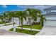 Beautiful two-story home with lush landscaping, a patterned driveway, and a white three-car garage at 6528 Simone Shores Cir, Apollo Beach, FL 33572