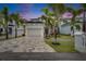 Beautiful two-story home with lush landscaping, a patterned driveway, and a white three-car garage at 6528 Simone Shores Cir, Apollo Beach, FL 33572